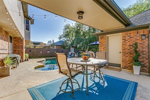 view of patio featuring a swimming pool with hot tub