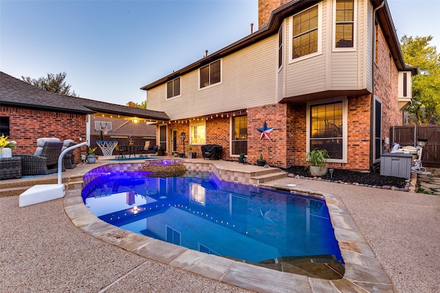 pool at dusk with a patio