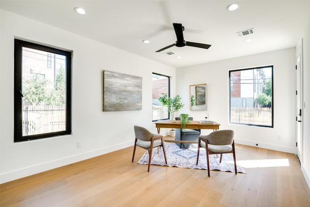 dining room with ceiling fan, a wealth of natural light, and light wood-type flooring