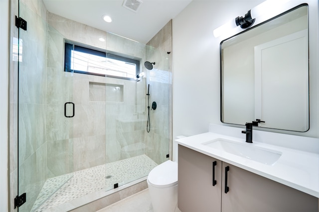 bathroom with vanity, toilet, tile patterned floors, and a shower with shower door