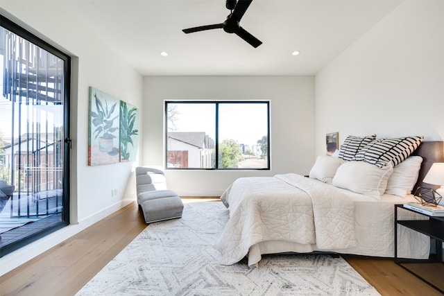 bedroom with access to exterior, hardwood / wood-style flooring, and ceiling fan