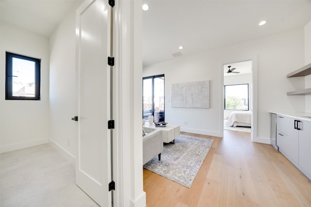 hallway featuring a healthy amount of sunlight and light wood-type flooring