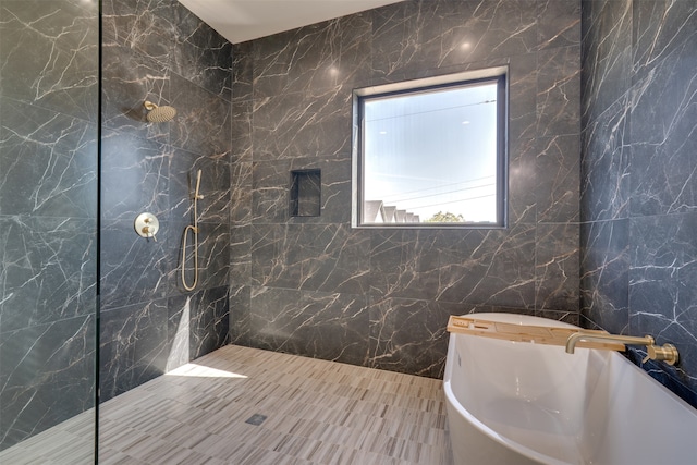 bathroom featuring independent shower and bath, sink, and tile walls