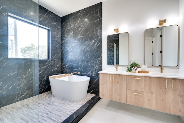 bathroom with vanity, a tub to relax in, tile walls, and tile patterned flooring