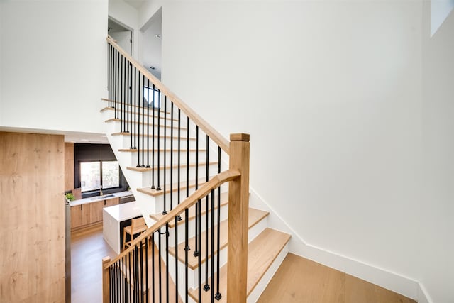 stairway featuring wood-type flooring and sink