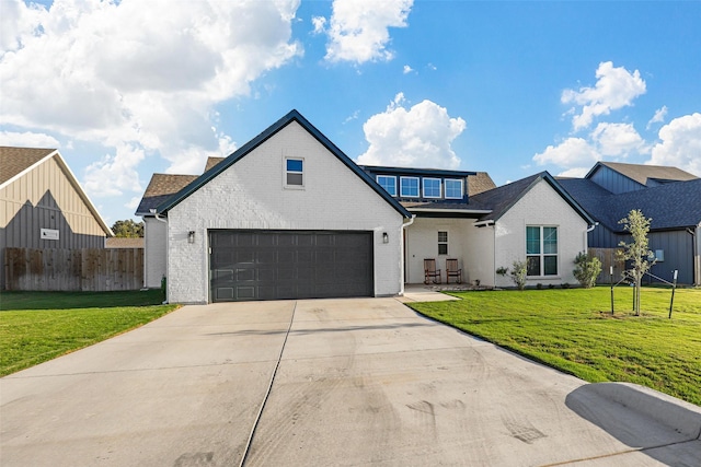 view of front facade with brick siding, fence, a garage, a front lawn, and concrete driveway