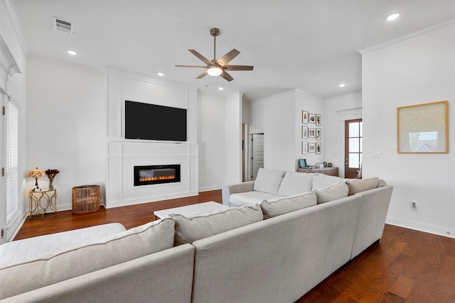 living area featuring recessed lighting, a glass covered fireplace, dark wood-type flooring, a ceiling fan, and visible vents