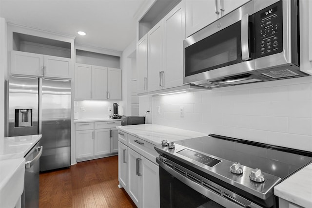 kitchen featuring dark wood-style floors, recessed lighting, stainless steel appliances, backsplash, and white cabinetry
