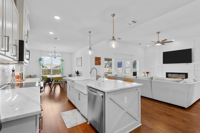 kitchen featuring sink, white cabinetry, stainless steel appliances, pendant lighting, and a kitchen island with sink