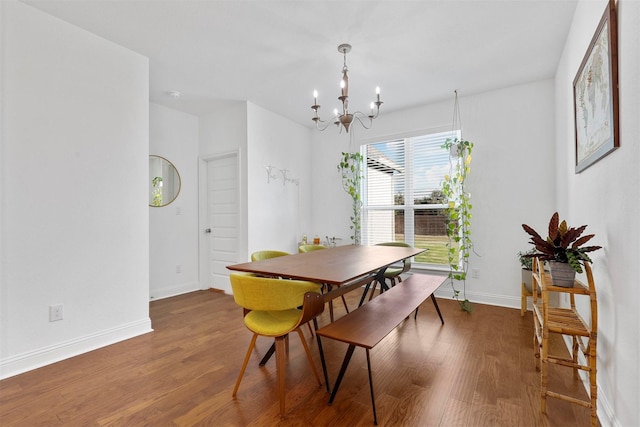 dining space with an inviting chandelier, wood finished floors, and baseboards