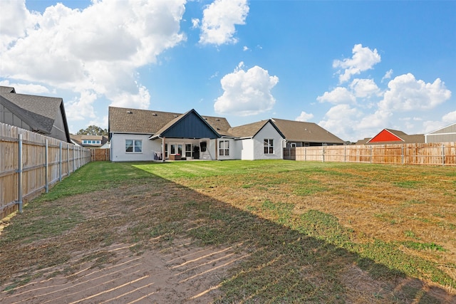 rear view of property featuring a yard