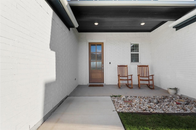 doorway to property featuring brick siding