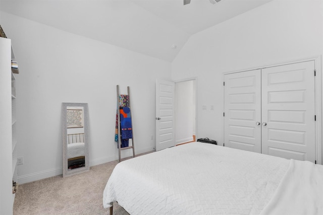 bedroom with light colored carpet, a closet, ceiling fan, baseboards, and high vaulted ceiling