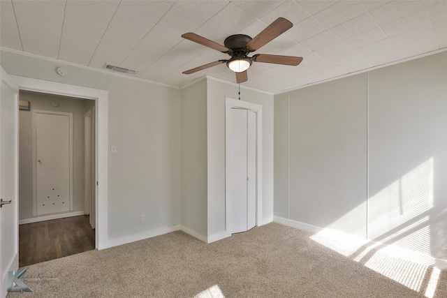 unfurnished bedroom featuring ornamental molding, carpet flooring, and ceiling fan