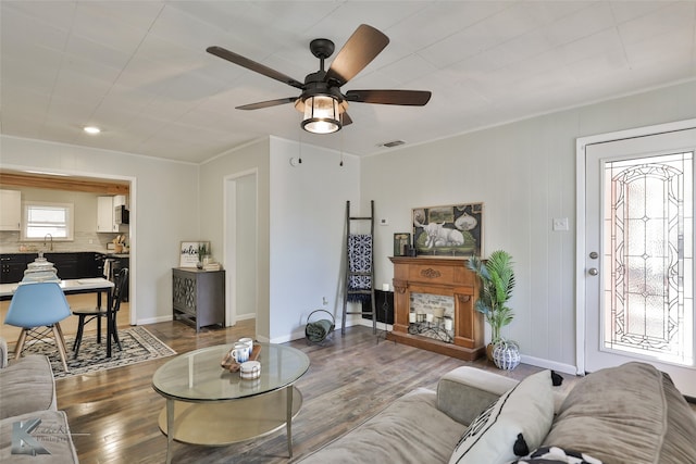 living room featuring ornamental molding, hardwood / wood-style floors, sink, and ceiling fan