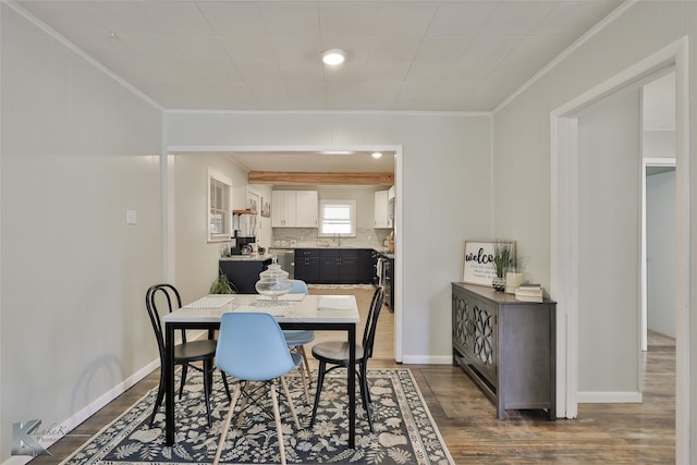 dining space with dark wood-type flooring, ornamental molding, and sink