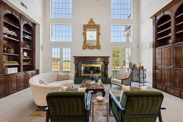 interior space with french doors, a towering ceiling, and light colored carpet