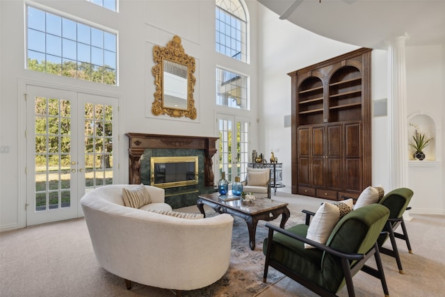 carpeted living room with a high ceiling, french doors, and a premium fireplace