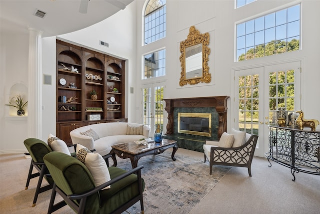 living room with a wealth of natural light, a high ceiling, and french doors