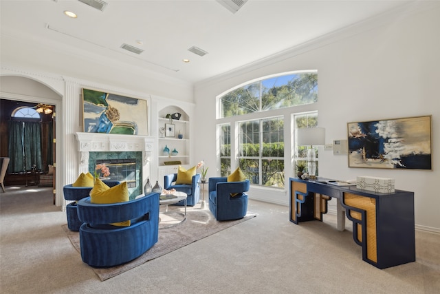 living room featuring built in shelves, a fireplace, carpet, and ornamental molding