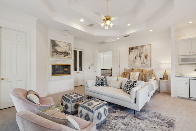 bedroom featuring a tray ceiling, ceiling fan, light colored carpet, and ornamental molding