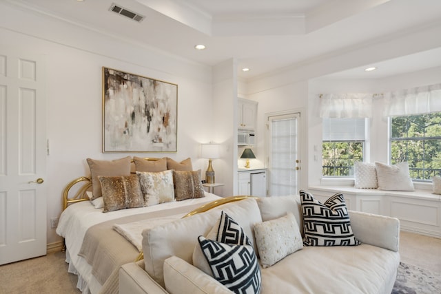 bedroom featuring light carpet, a tray ceiling, and ornamental molding