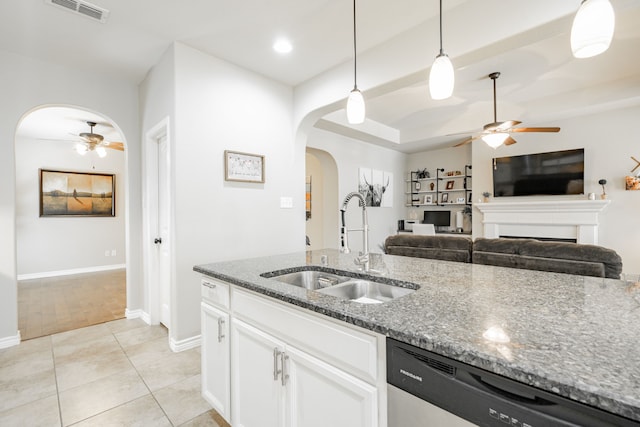 kitchen featuring sink, pendant lighting, stainless steel dishwasher, white cabinetry, and light stone counters