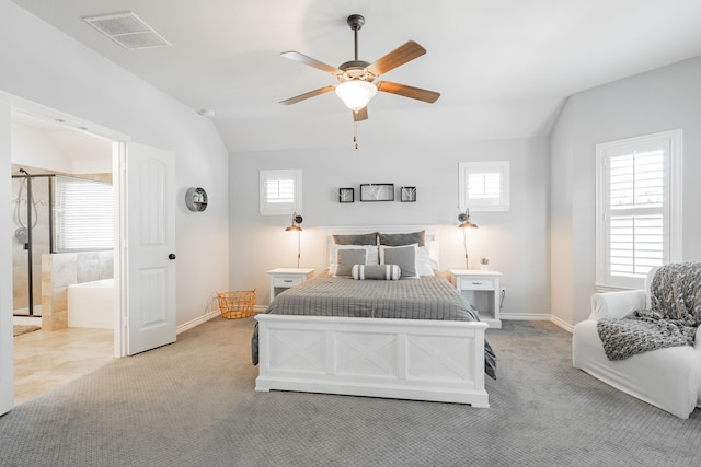 bedroom with connected bathroom, ceiling fan, vaulted ceiling, and light colored carpet