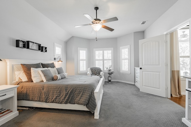 carpeted bedroom featuring multiple windows and ceiling fan