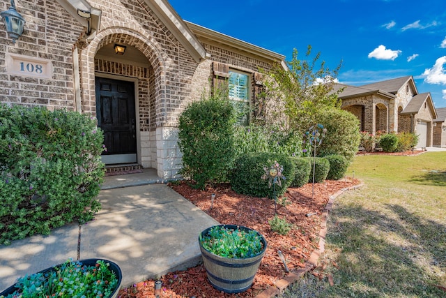 property entrance with a garage and a lawn