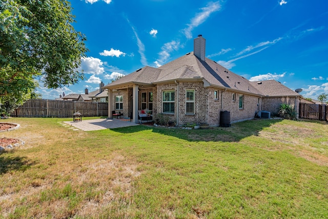 rear view of house with a patio area, central AC, and a lawn