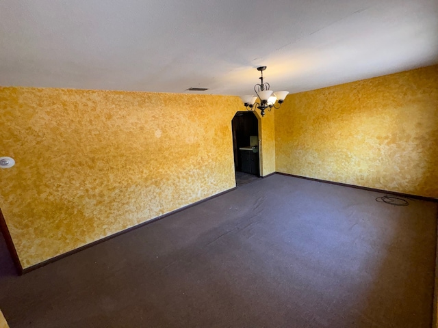 unfurnished room featuring an inviting chandelier