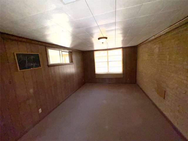 unfurnished room with wooden walls and brick wall