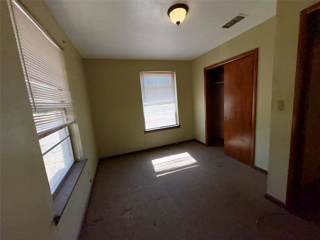 unfurnished bedroom with light carpet and a closet