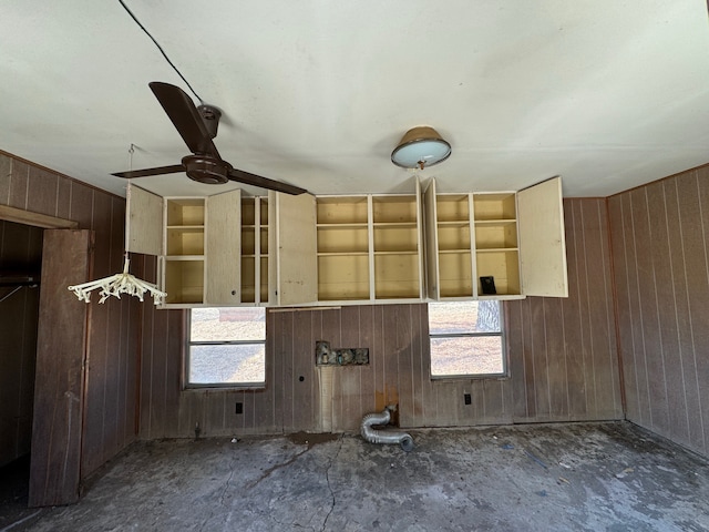 interior space with wooden walls and ceiling fan