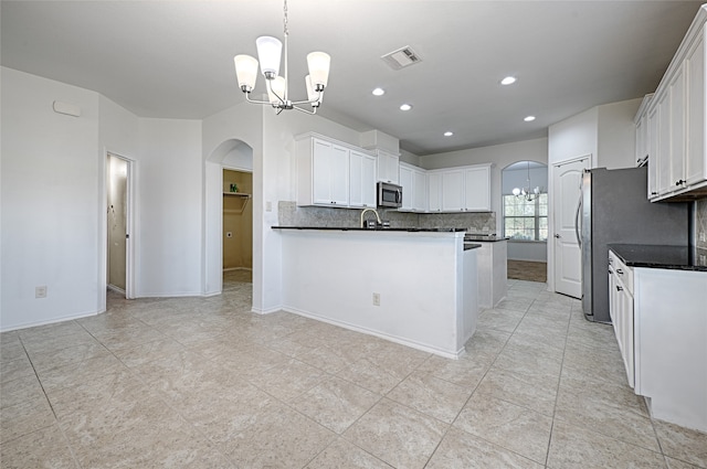 kitchen with light tile patterned flooring, hanging light fixtures, white cabinets, decorative backsplash, and an inviting chandelier