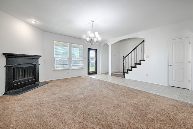 unfurnished living room featuring a notable chandelier and light colored carpet