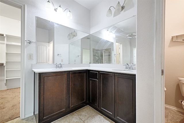 bathroom featuring vanity, a shower with shower door, toilet, and tile patterned flooring