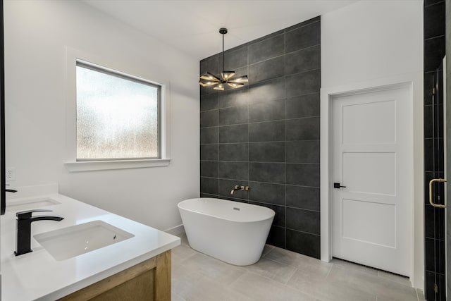 bathroom with separate shower and tub, tile walls, vanity, an inviting chandelier, and tile patterned flooring