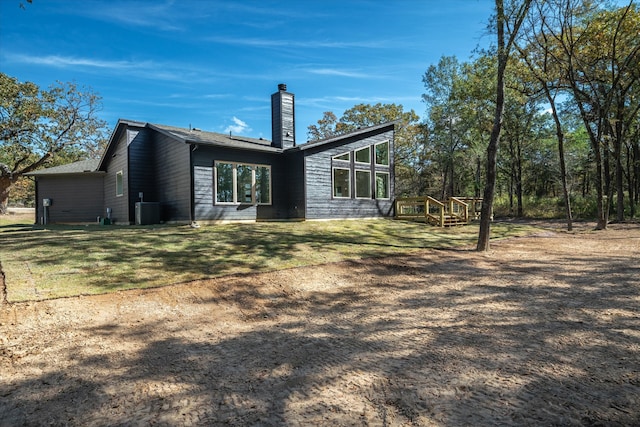 rear view of property with a yard and central AC