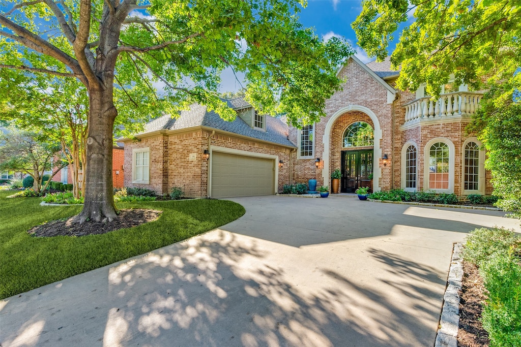 english style home featuring a front lawn and a garage