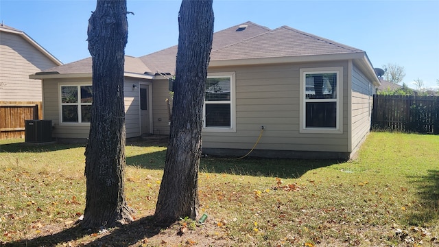 back of property featuring central AC and a lawn