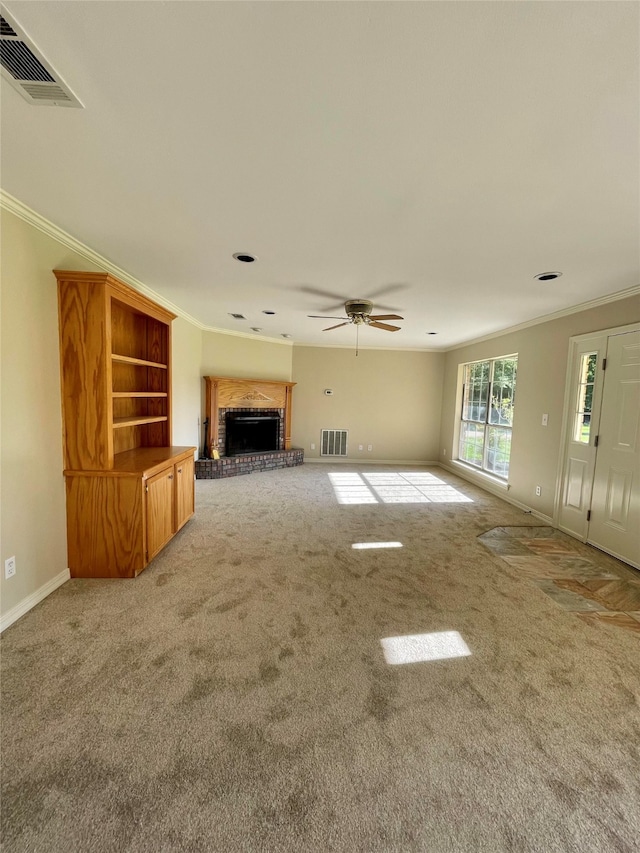 unfurnished living room featuring a brick fireplace, visible vents, and crown molding