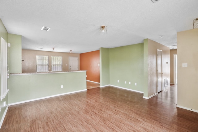 unfurnished room featuring a textured ceiling and wood-type flooring