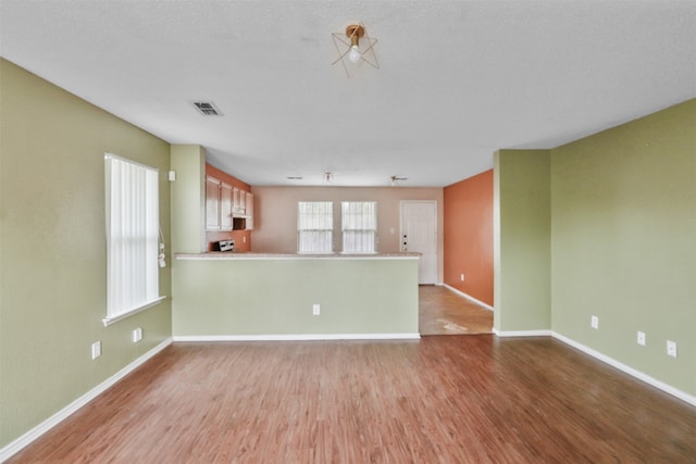 unfurnished room featuring light hardwood / wood-style flooring and a textured ceiling