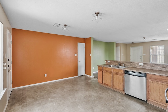 kitchen with a textured ceiling, stainless steel dishwasher, and sink