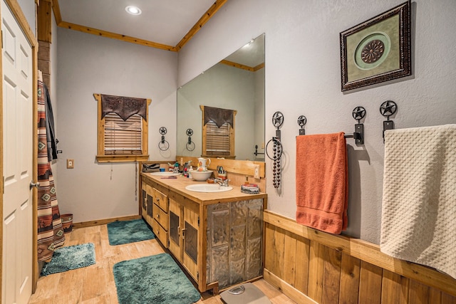 bathroom with crown molding, vanity, and hardwood / wood-style flooring