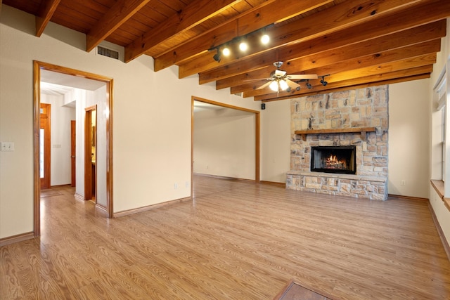 unfurnished living room featuring a stone fireplace, light hardwood / wood-style floors, ceiling fan, wooden ceiling, and beam ceiling