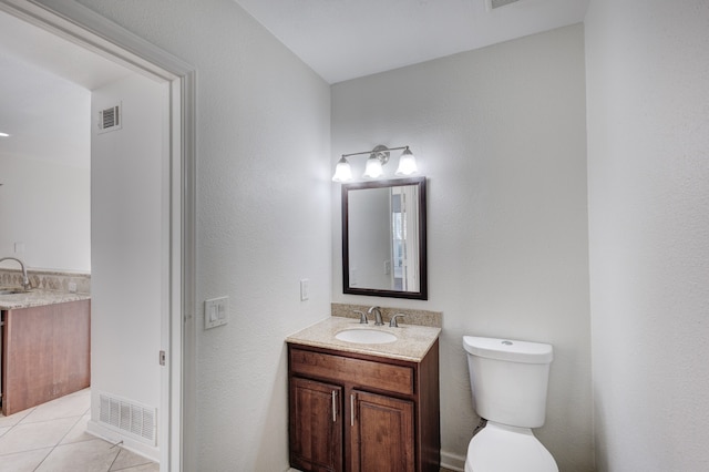 bathroom with vanity, toilet, and tile patterned flooring