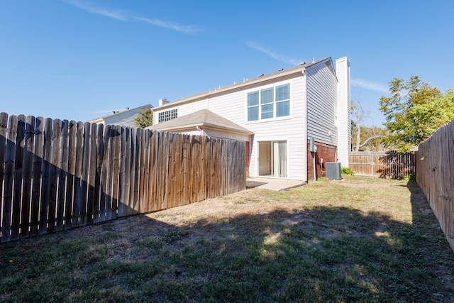 rear view of house with a yard and central air condition unit